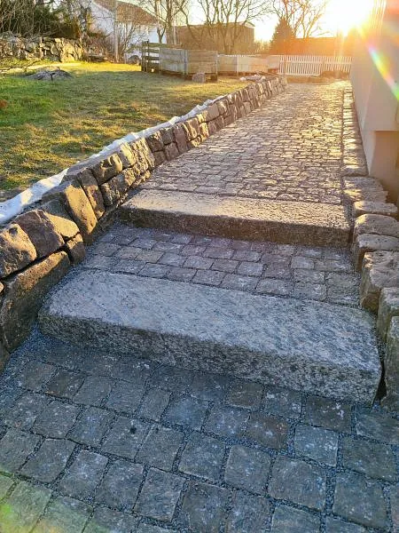 Stentrappa med stödmur i solnedgång
